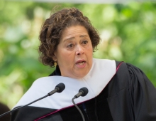 portrait of Anna Deveare Smith speaking at a podium in graduation robes